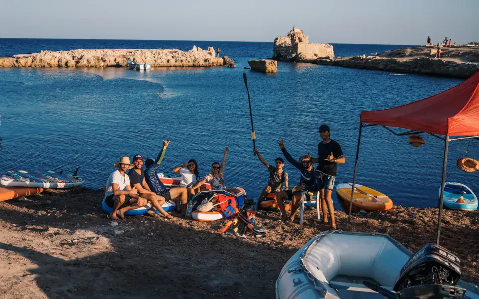 Groupe sur la plage devant le matériel et le bateau du club