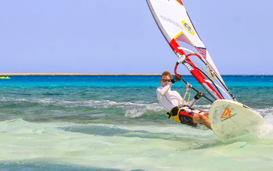 Une kitesurfeuse dans l'eau, avec un kite Cabrinha et sa planche