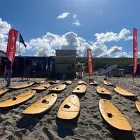 Planches de surf alignées sur la plage devant le pavillon