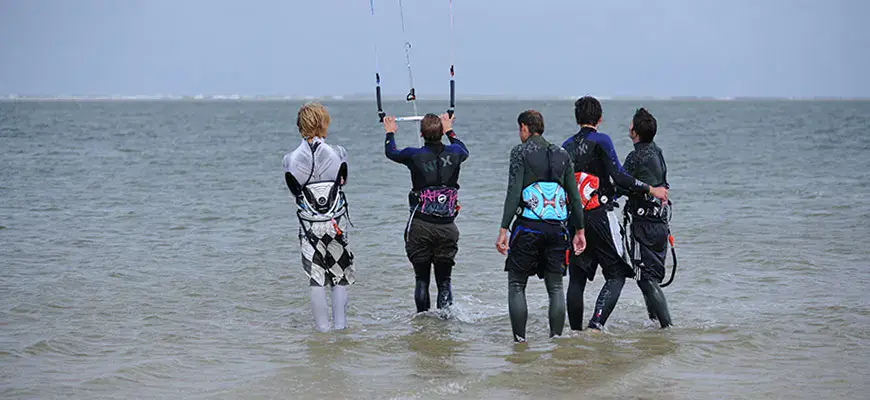 Cours de groupe : élèves dans l'eau avec leurs barres de kite