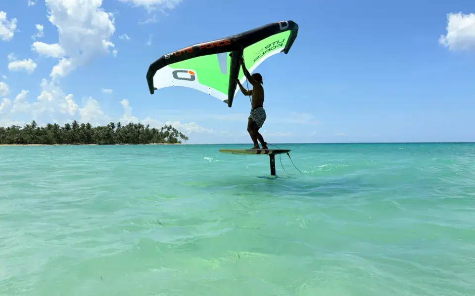 Rider en wing foil sur eau turquoise