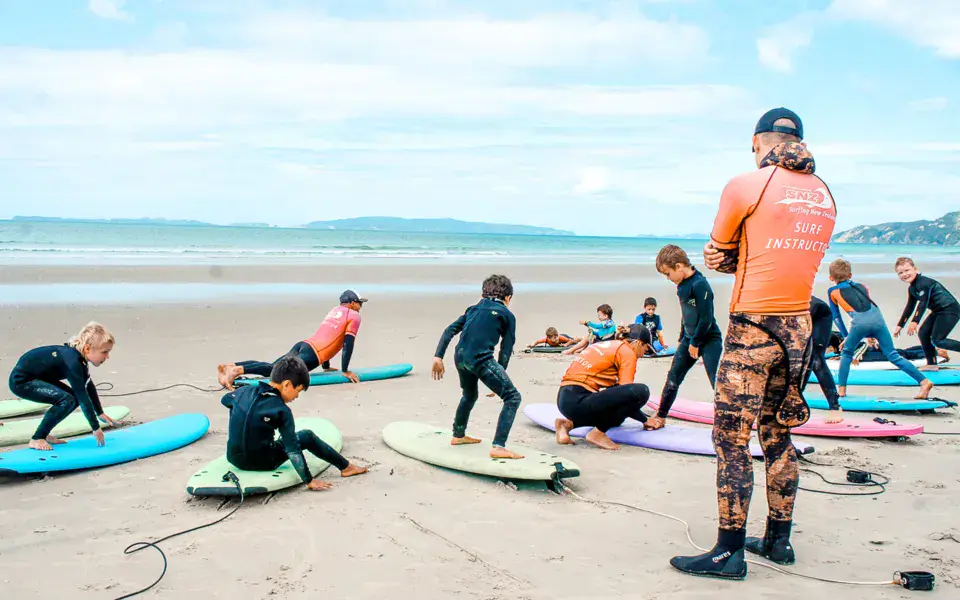 Cours de surf sur la plage, les élèves allongés sur leur planche