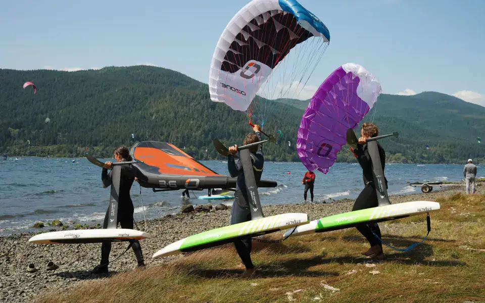 Pratiquants de parawing sur une plage, avec leurs planches
