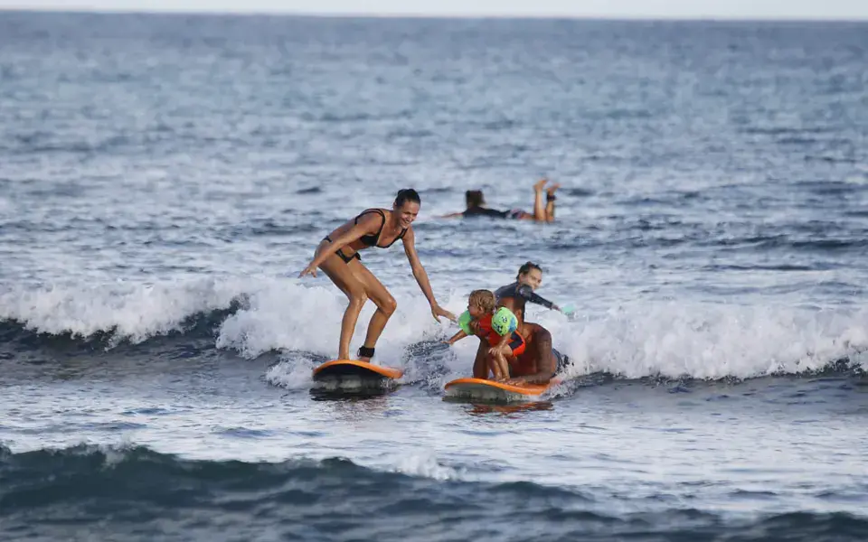Cours de surf avec un moniteur et des élèves dans l'eau