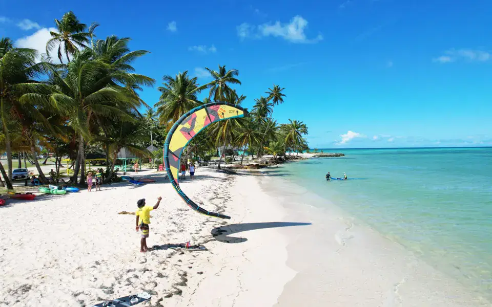 Plage de sable blanc avec un kite au décollage