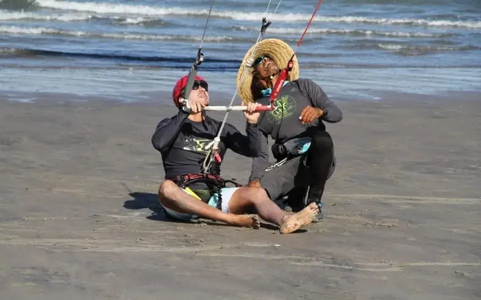 Moniteur et élève sur la plage avec une aile d'entraînement