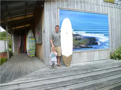 Façade en bois de l'atelier, avec une planche blanche devant la grande fresque