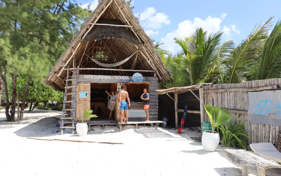 Cabane en chaume de l'école de kitesurf sur la plage de sable blanc