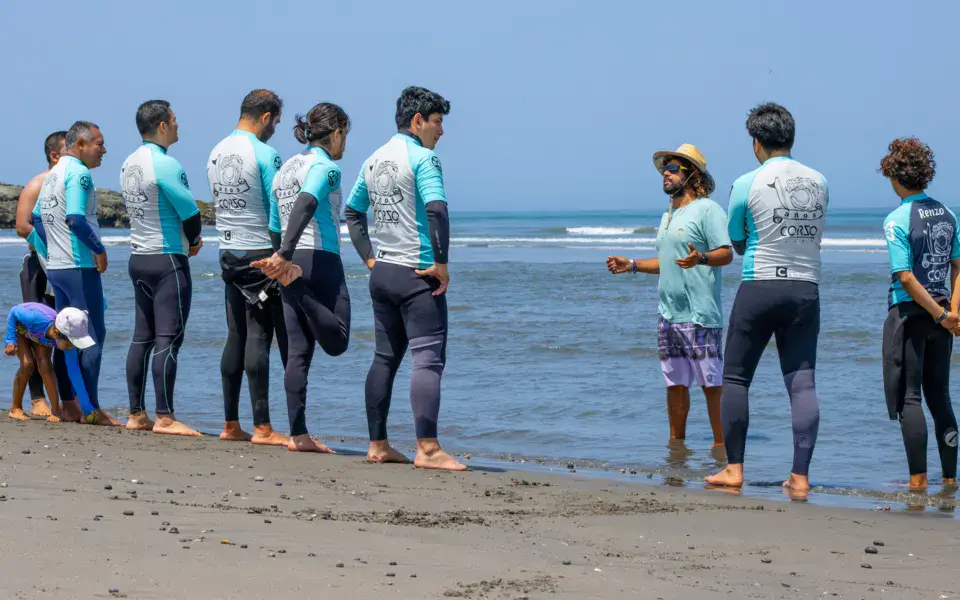 Briefing d'un groupe d'élèves sur la plage avant le cours