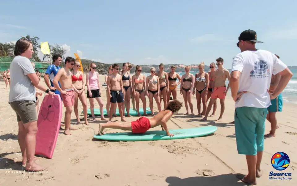 Cours de surf collectif sur la plage, explications du moniteur