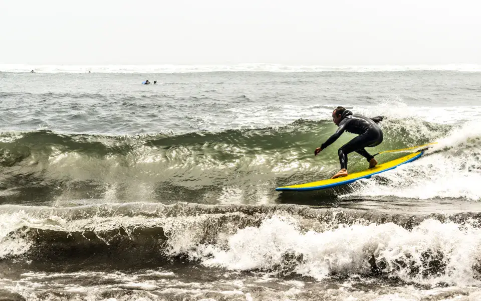 Surfeur sur une planche jaune dans les vagues