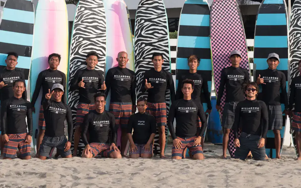 L'équipe de moniteurs de l'école de surf devant les planches