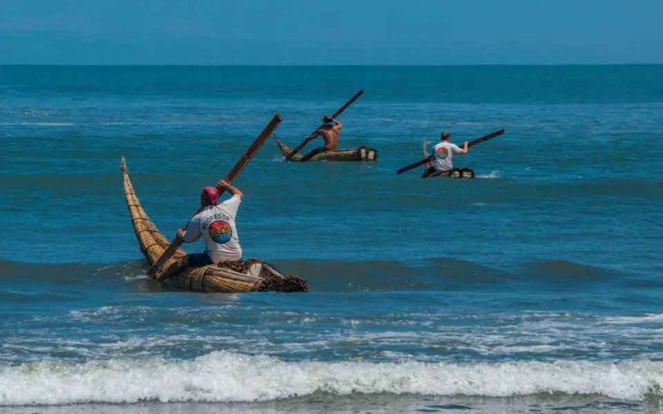 Pêcheurs sur des caballitos de totora dans les vagues de Huanchaco
