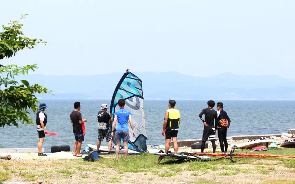 Groupe sur la rive du lac Hamana avec le matériel de windsurf
