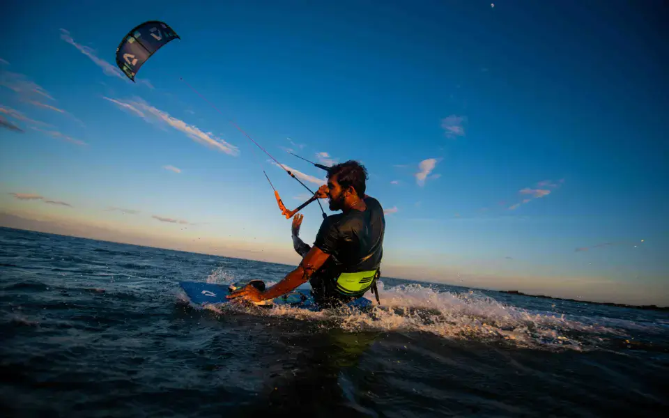Un kitesurfeur dans le lagon au coucher du soleil