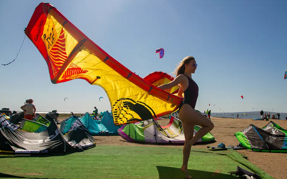 Aile déployée sur la plage, au milieu du matériel de kite