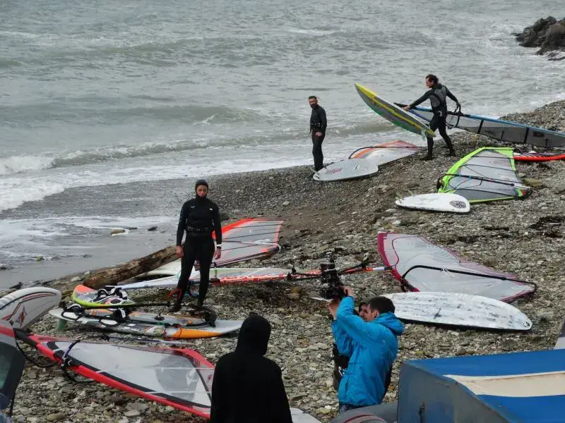 Planches de windsurf alignées sur la plage de galets