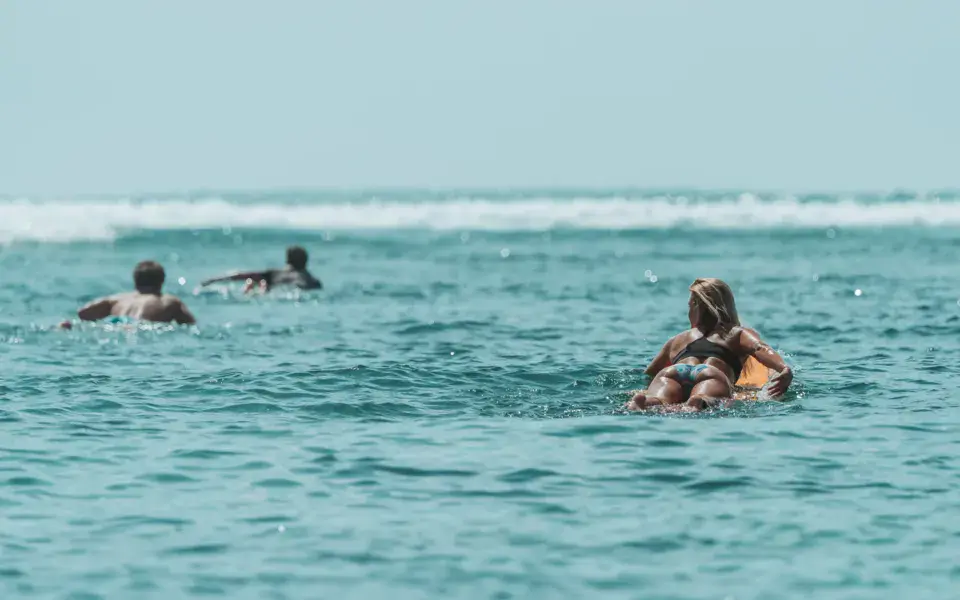 Élèves et coach dans l'eau, en attente de la prochaine vague
