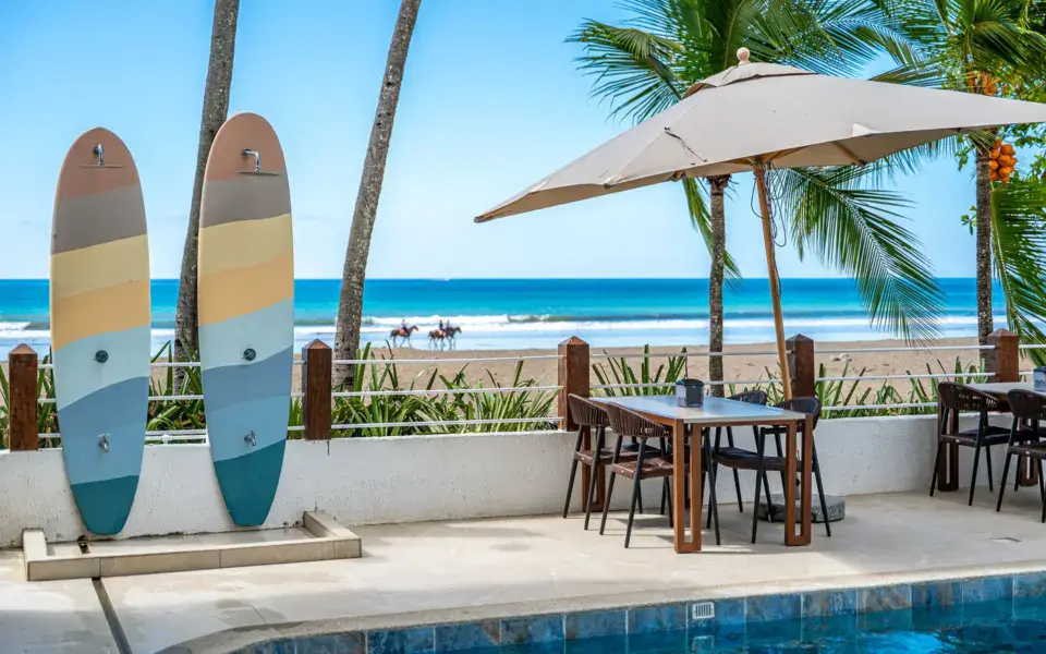 Planches de surf devant la plage, à côté d'une terrasse