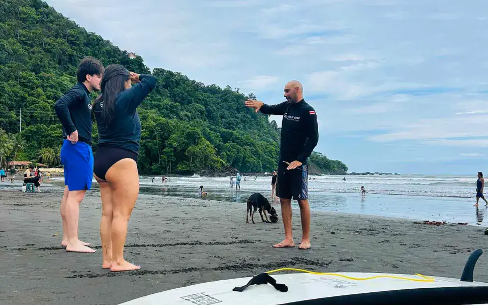 Explications d'un moniteur à deux élèves sur la plage